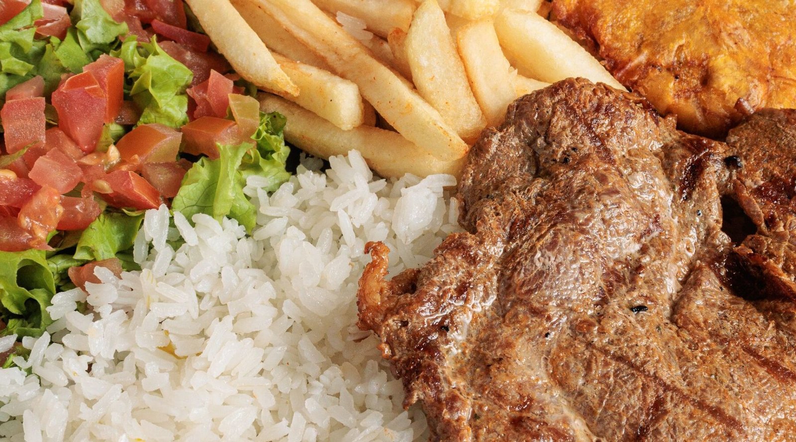 Traditional Colombian bandeja paisa with grilled meat, rice, beans and plantain