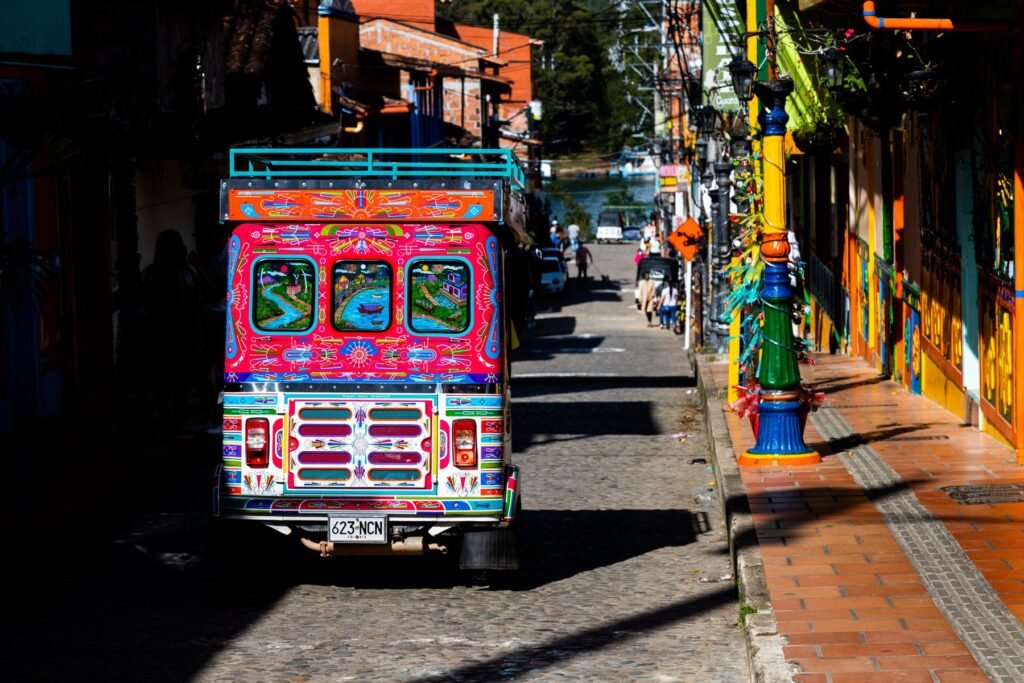 A colourful chiva bus on a painted street in Guatapé, Antioquia