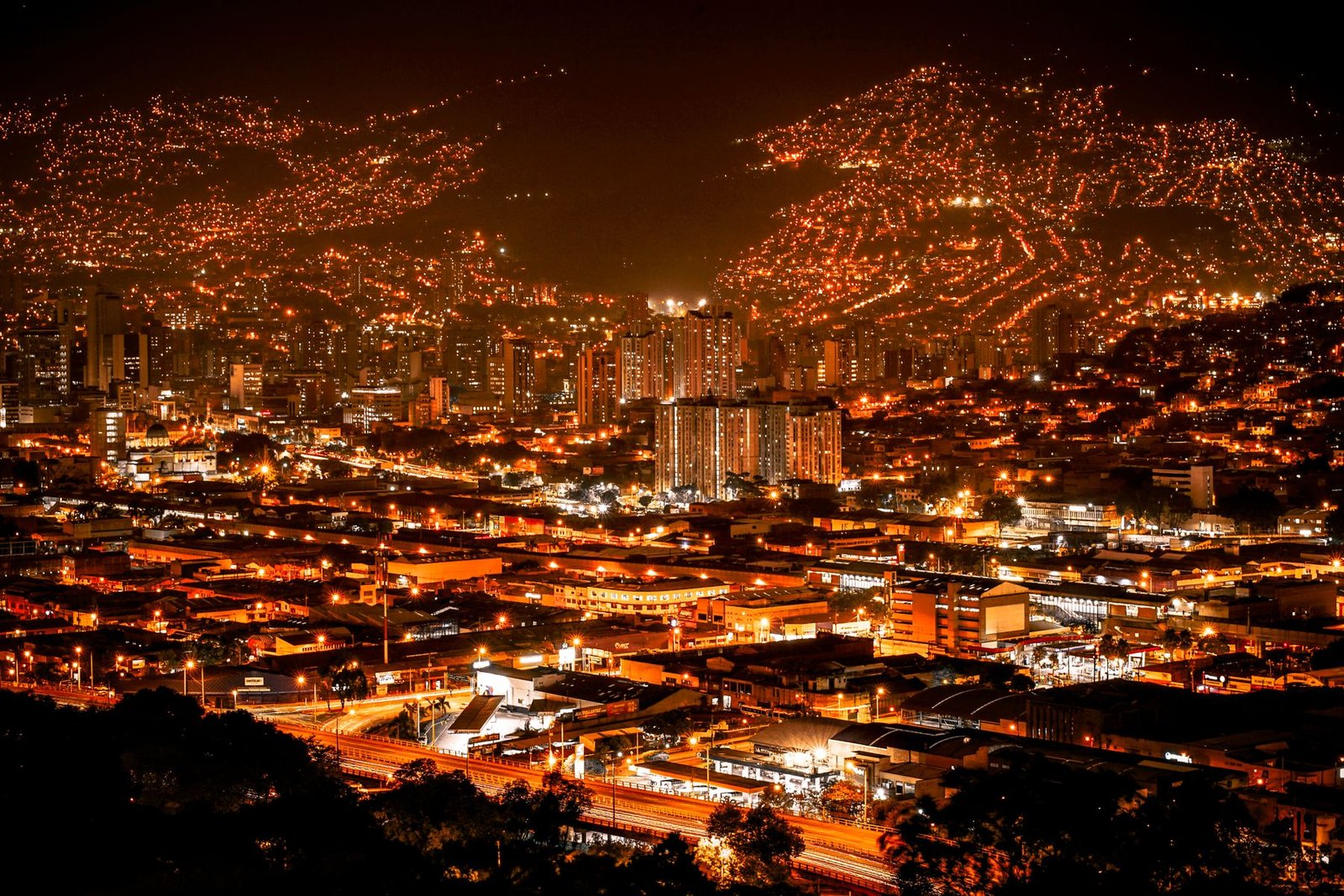 Medellín at night, the valley lit up in orange from the hillside