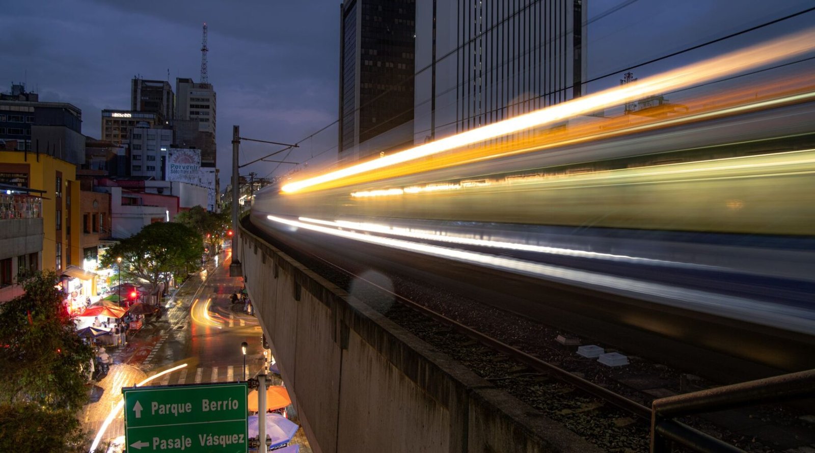Long-exposure shot of a Medellín Metro train passing through the city at night