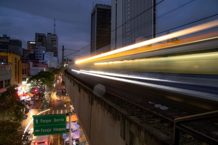Long-exposure shot of a Medellín Metro train passing through the city at night