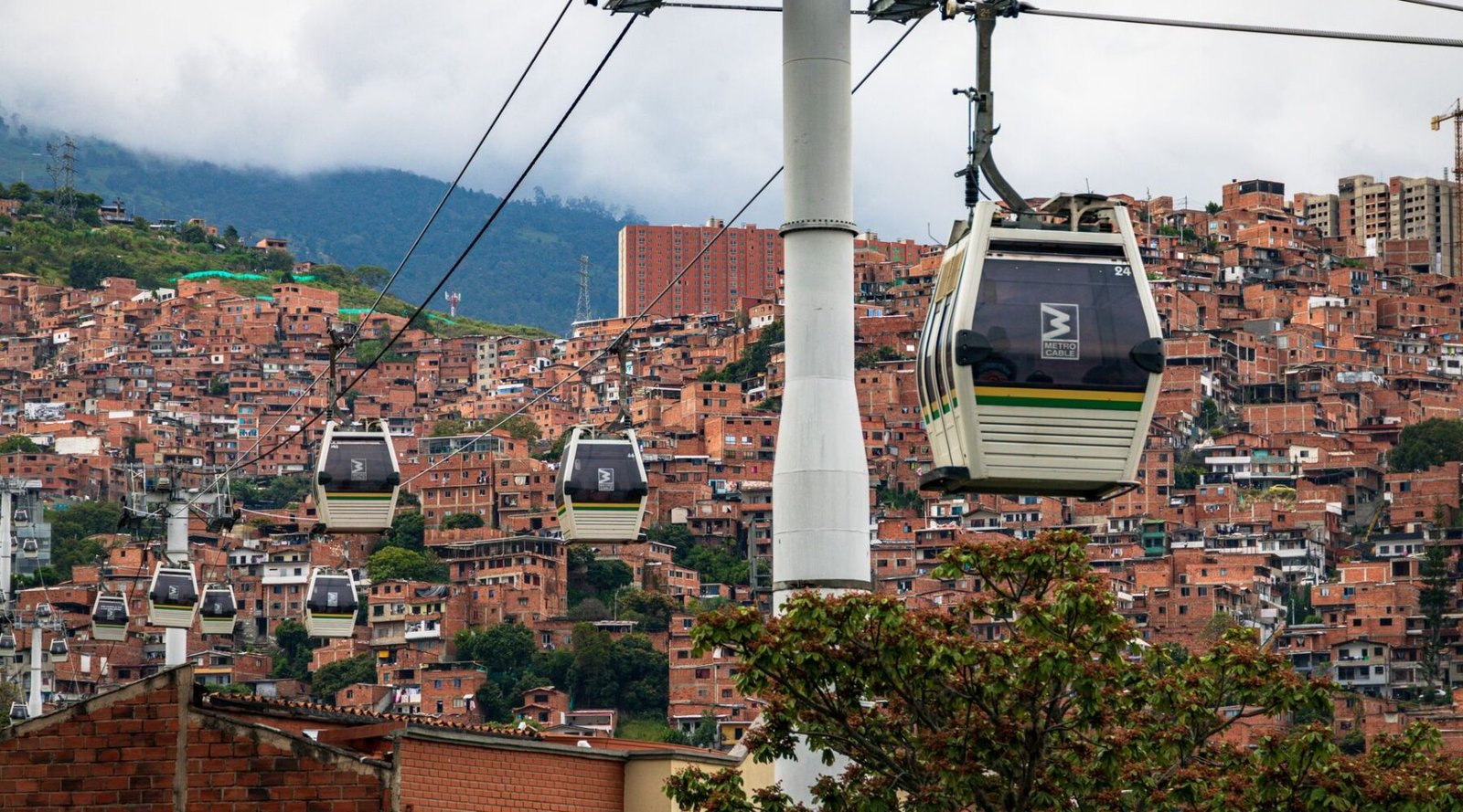 Metrocable gondolas over the terracotta rooftops of Medellín hillside neighbourhoods