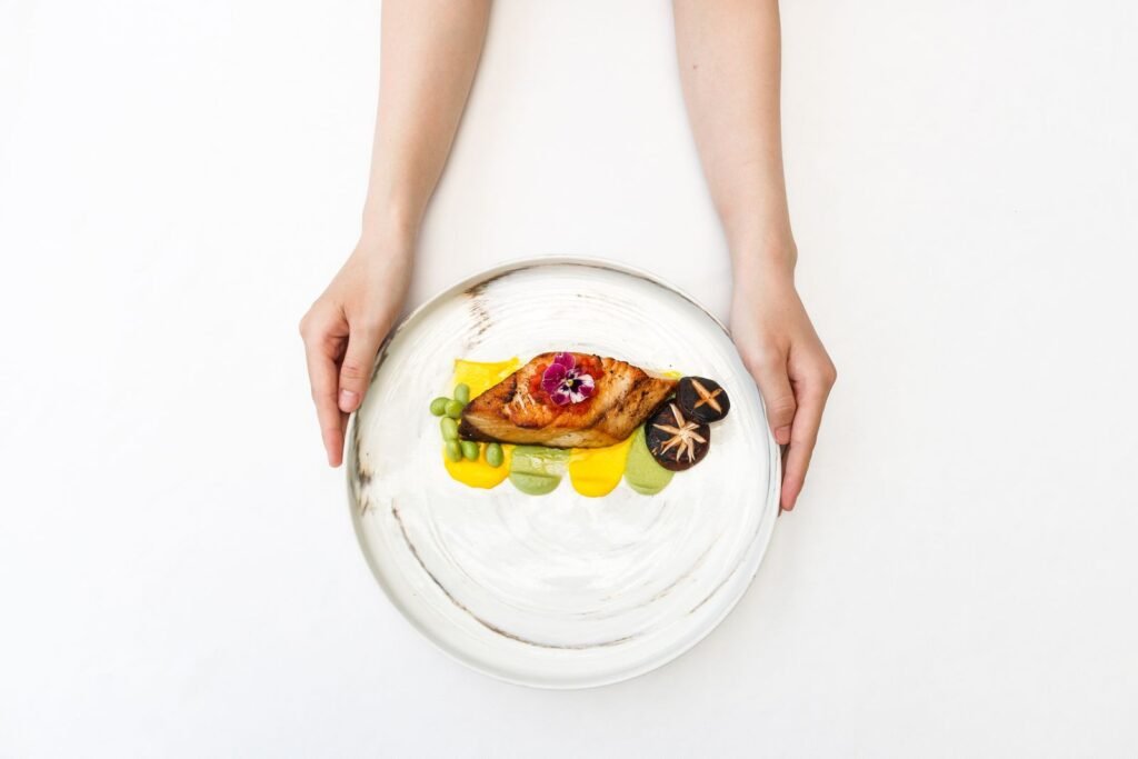 A small plated gourmet dish garnished with mushrooms and an edible flower